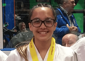 Smiling girl with glasses and gold medal