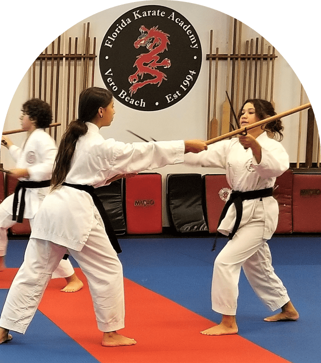 Karate students spar with wooden staffs