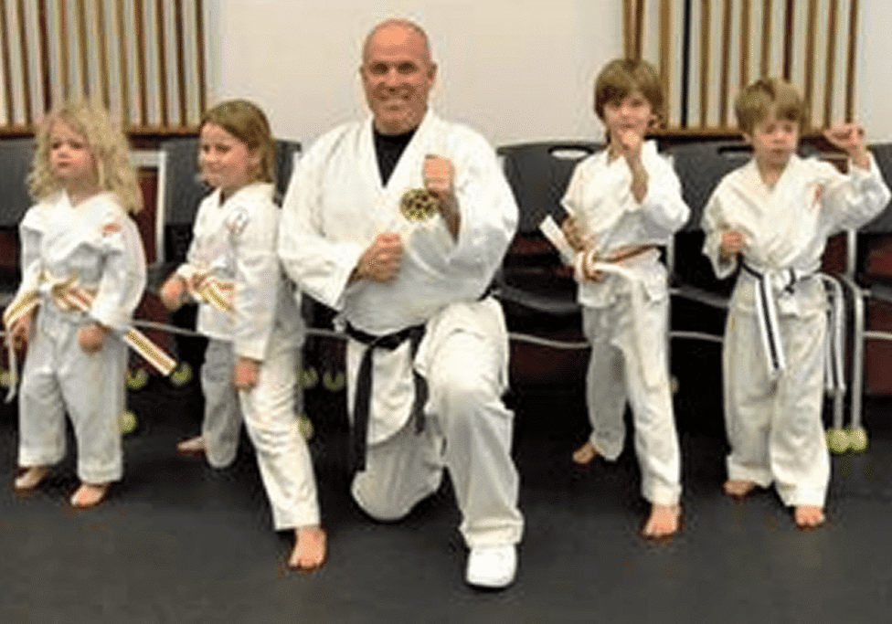 Karate class posing with belts